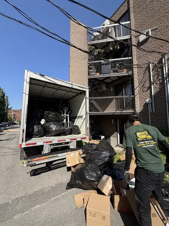 Intervention résidentielle à Lachine : camion ouvert rempli de sacs, un employé ByeByeJunk trie les boîtes